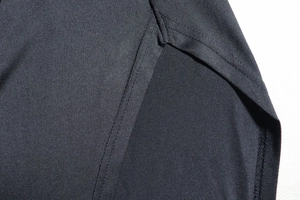 Detailed close-up of side slit and reinforced stitching on a black one-shoulder dress