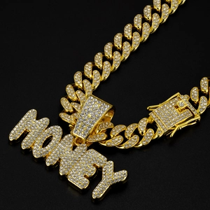 Macro shot of gold-plated cuban link chain with money letter pendant and pavé rhinestones