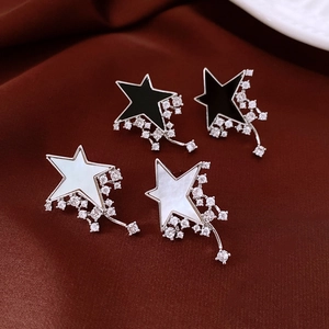Macro shot of star and meteor stud earrings with inlaid zircon and mother of pearl detail