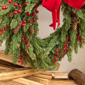 Detailed view of 50cm Christmas wreath with red berries and pine cones on wood background