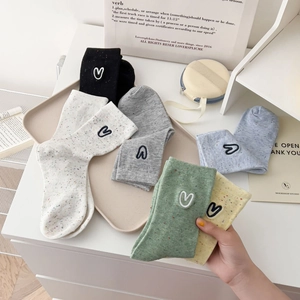 Detail of colorful speckled cotton socks with heart embroidery in diverse colors