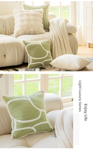 Close-up of soft green knitted cushion cover with abstract pattern and cream velvet texture