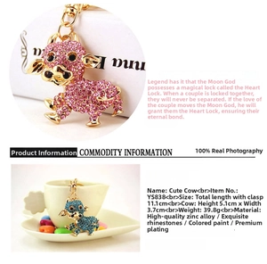 Dettaglio di portachiavi a forma di mucca colorata con strass scintillanti in rosa e blu
