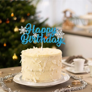 Blue glitter snowflake Happy Birthday cake topper on a white snowy cake for winter parties