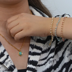 Gros plan d'un collier doré avec pendentif en amazonite vert menthe sur le cou d'un mannequin