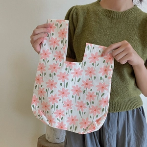 Detail view of cotton floral wristlet pouch featuring pink flowers on white fabric