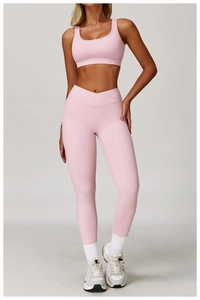 Pink yoga set detail featuring criss-cross high waist leggings and a U-neck sports bra
