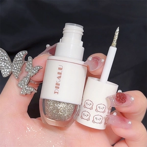 Primo piano dell'ombretto liquido glitterato argento con applicatore a pennello sottile
