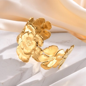 French vintage gold stainless steel flower cuff bracelet on marble and silk background
