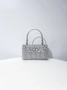 Detailed macro view of silver rhinestone handbag with crystal flower and fringe fringe fringe
