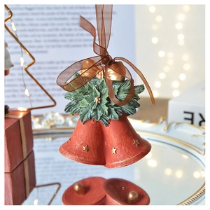 Macro view of vintage red Christmas bells with golden stars and green holly leaves