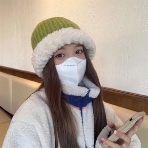 Winter plush knitted hat in green and white patchwork style for a warm seasonal look