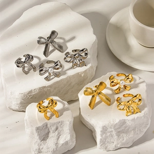 Retro 18K gold and silver bow rings with pearls on white stone, minimalist metal jewelry