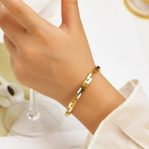 Golden titanium steel heart bracelet with LOVE engraving and white enamel inlay on wrist