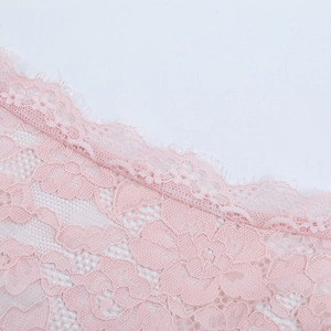 Close-up of pink floral lace fabric featuring delicate eyelash edge and fine texture