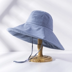 Detail of wide-brim sun hat in dusty blue with adjustable windproof strap and wavy edge