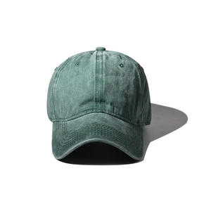 Front close-up of vintage dark green washed cotton baseball cap with curved brim and panels