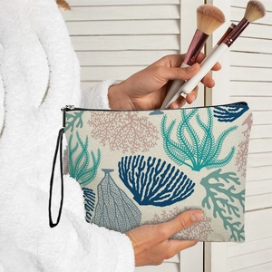 Trousse à maquillage en toile avec motifs de coraux et algues tenue par un mannequin