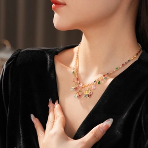 Close-up of a luxury flower necklace with colorful crystals on a black velvet dress