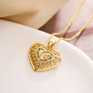Macro detail of gold heart pendant with colorful zircon stones and fe engraving