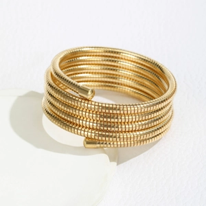 Detailed macro shot of gold multi-layer spiral bracelet with fine threaded texture