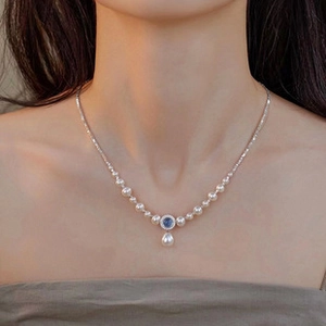 Detailed shot of s925 silver necklace with white pearls and dark blue crystal pendant