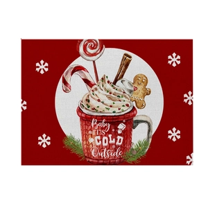 Close-up of red linen Christmas placemat with hot cocoa illustration and snowflake pattern