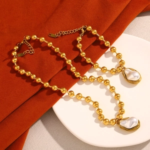 Detail of 18K gold-plated beaded bracelets with natural white baroque pearl pendants