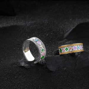 Detail of gold and silver open rings with colorful enamel floral clover patterns