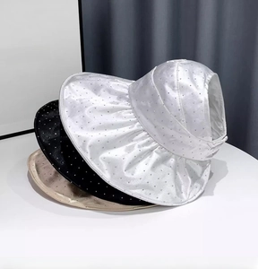 Detail of satin sun visors with rhinestones in white black and beige colors
