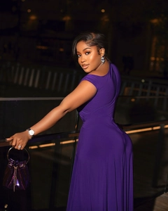 Close-up of purple one-shoulder slim dress paired with luxury metallic bucket bag