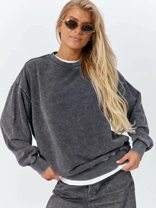 Detailed view of washed grey cotton sweatshirt showing vintage texture and ribbed neckline