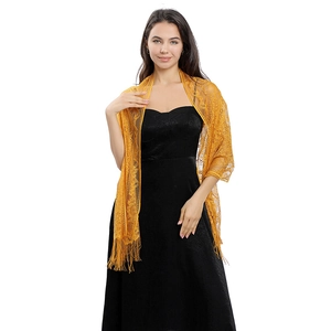 Close-up of ginger yellow lace shawl featuring intricate floral hollow and long tassels