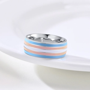 Close-up of a stainless steel ring featuring transgender pride flag colored stripes.