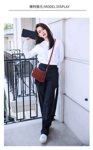 Outdoor model display of a vintage red plaid baguette bag with slim shoulder strap