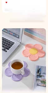 Detailed view of pink and purple cherry blossom silicone heat-resistant mats on a white desk