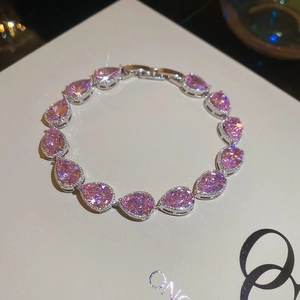 Macro shot of silver bracelet with pear-cut pink zircons and classic claw setting
