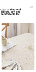 Close-up of beige linen tablecloth with delicate white daisy embroidery and soft texture