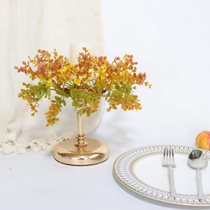 Golden candle holder with autumn eucalyptus leaf wreath and white pillar candle