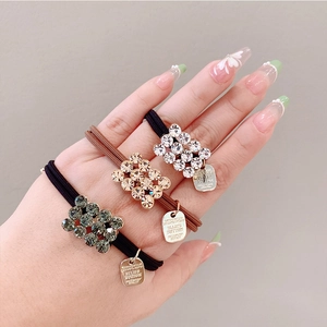 Sparkly rhinestone hair ties for ponytails shown in black and brown on a model