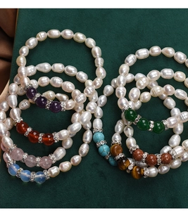 Detailed view of stacked freshwater pearl bracelets with colorful gemstone beads and spacers
