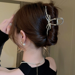 Silver bow hair claw clip styled in an elegant updo hairstyle for a sophisticated look
