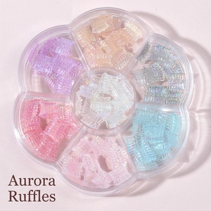 Detailed top view of aurora colorful skirt-shaped nail charms in a flower storage box