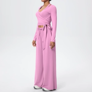 Détail du crop top à manches longues croisées et pantalon de yoga large taille haute