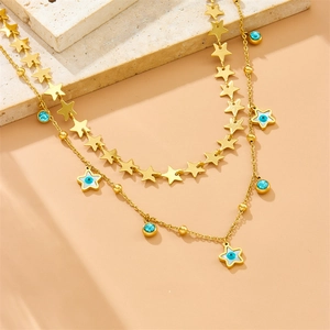 Detail of double-layer gold necklace with turquoise beads and star evil eye pendants