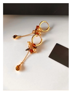 Detail of vintage gold drop earrings with tiger eye beads and elegant pearl tassels
