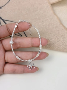 Detail of S925 silver beaded bracelet with freshwater pearls and flower pendant