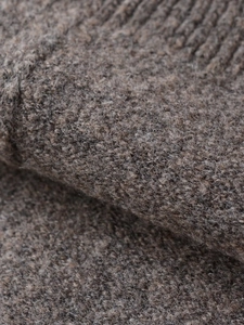Makroaufnahme der weichen Wollmischung und der Rippstrick-Details des braunen Strickjacke