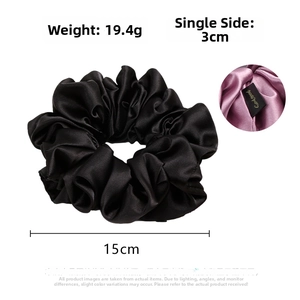 Macro detail of black satin scrunchie with 15cm width and 19.4g weight specifications