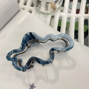 Cloud acetate shark hair clip with blue and white marble pattern on book
